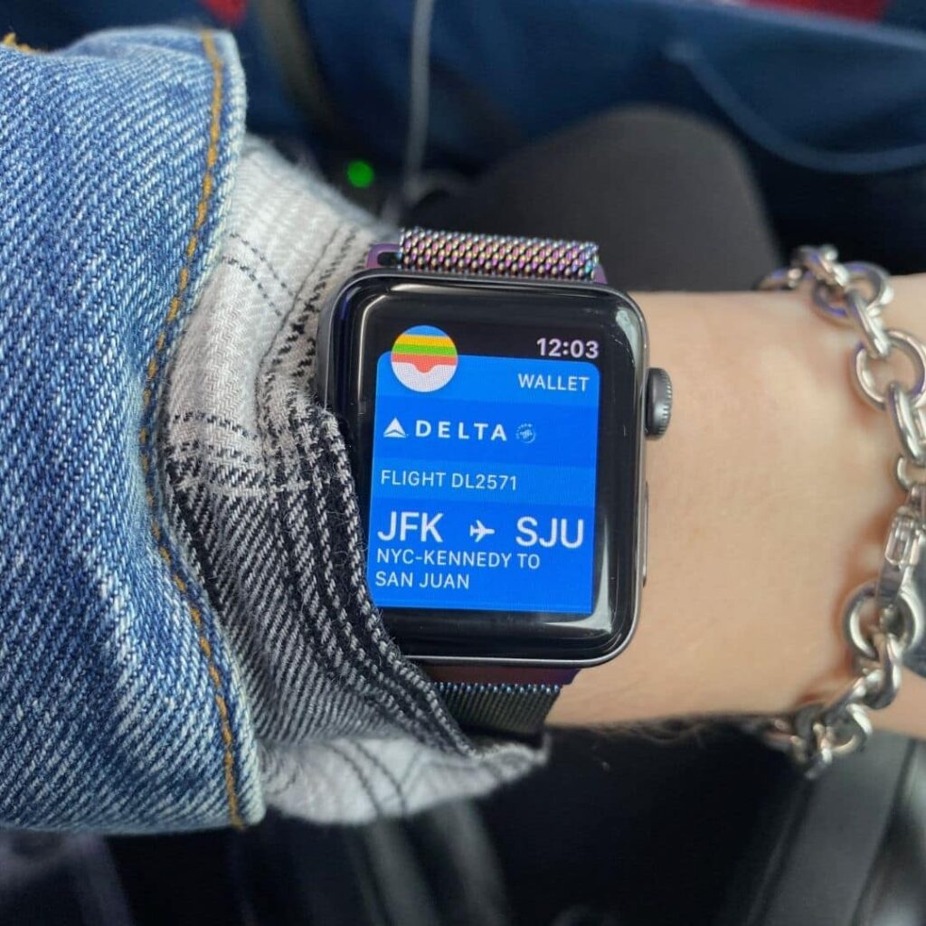 Closeup of a woman wearing a smart watch with a Delta boarding pass open on the screen.