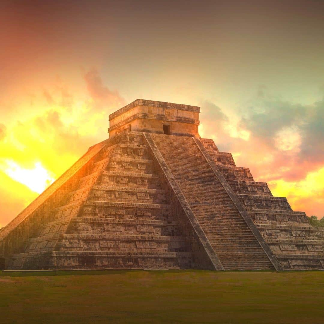 Photo of Chichen Itza in Mexico with the sun rising in the back.