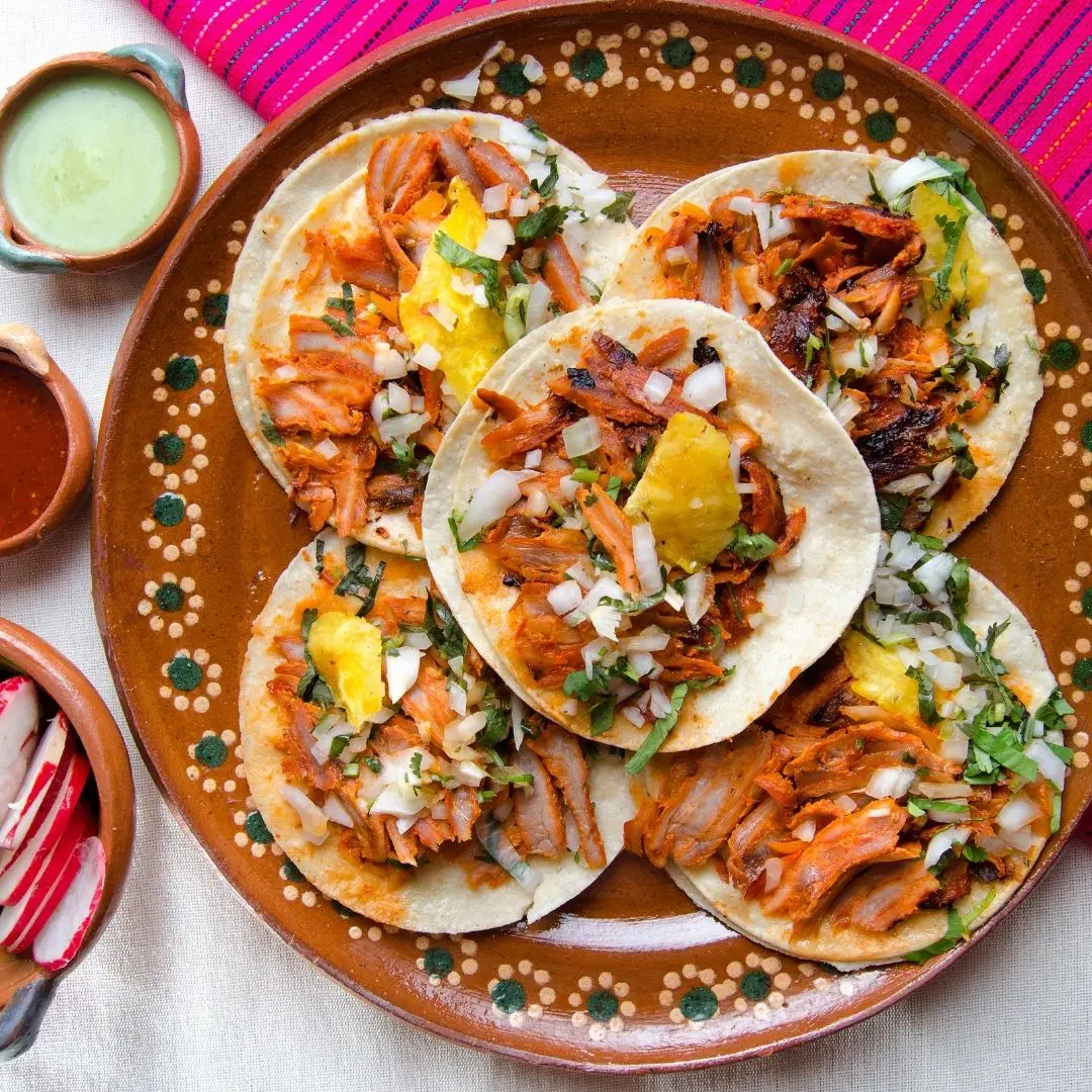 Closeup aerial view of a platter with tacos al pastor.