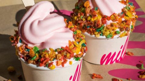 Closeup of 2 cups of pink soft serve ice cream from Milk with Fruity Pebbles cereal sprinkled on top.