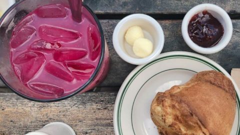 Flatlay photograph of a popover from Jordan Pond House and a glass of blueberry lemonade.