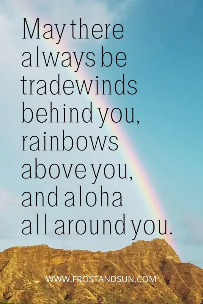 Photo of a rainbow reaching down toward a mountain in Hawaii.
