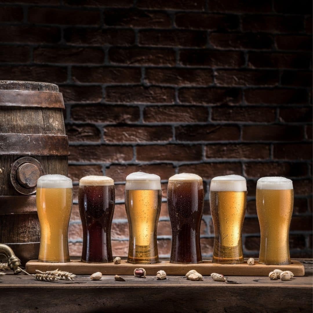 Closeup of a beer tasting board with 6 pints of beer.