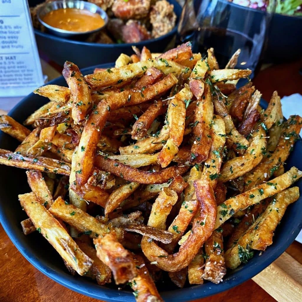 Closeup of a bowl of garlic herb shoestring french fries.