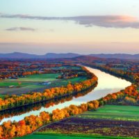Photo of the Connecticut River Valley in CT from the air with Fall foliage lining the river banks.