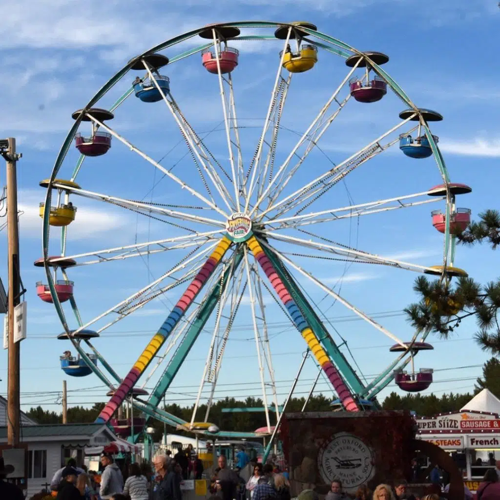 Photo of a colorful ferris wheel at a fair.