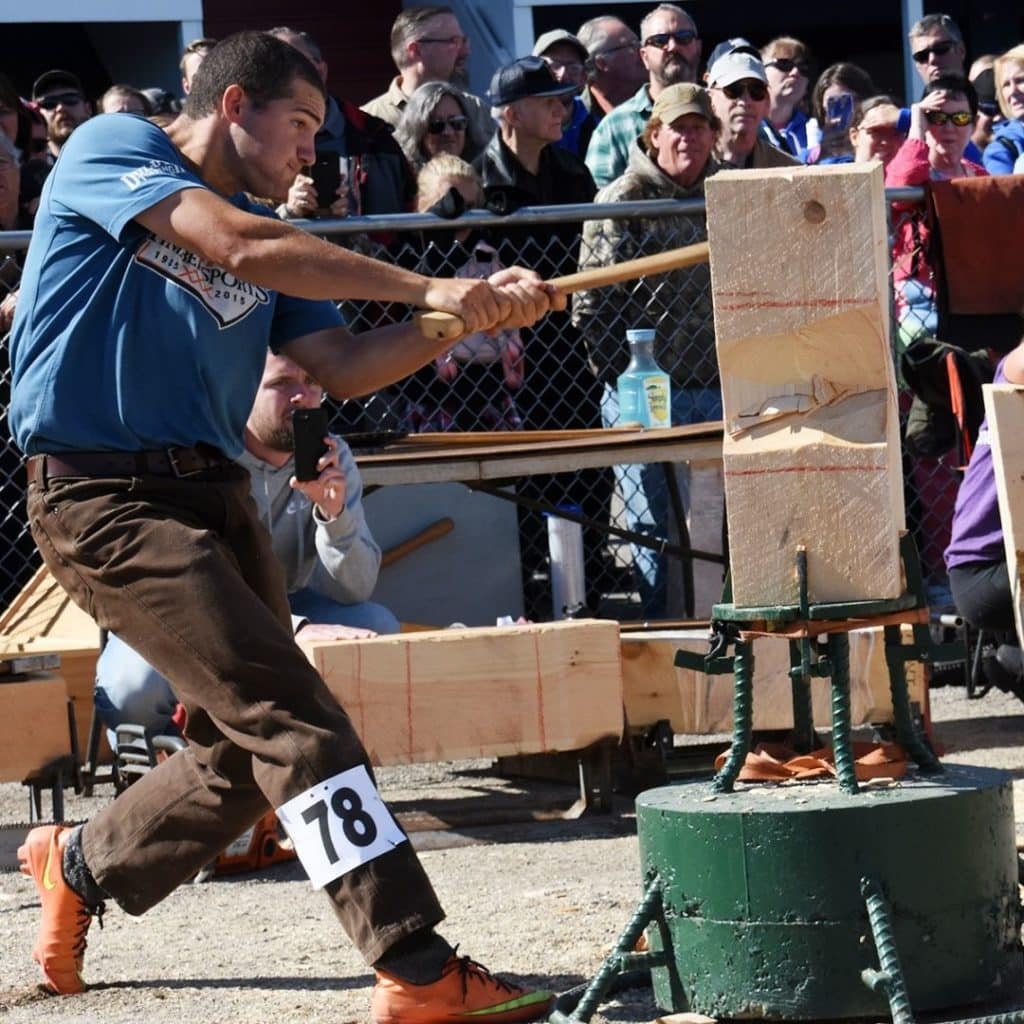 Closeup of a man competing in a lumberjack chopping contest.