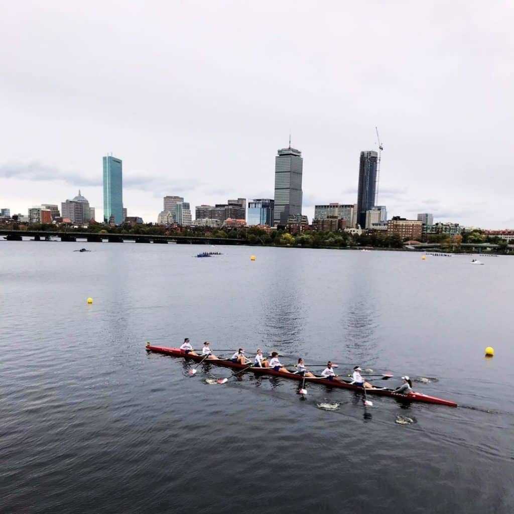 Photo of a team of rowers gliding down the Charles River during the Head of the Charles race in Boston.