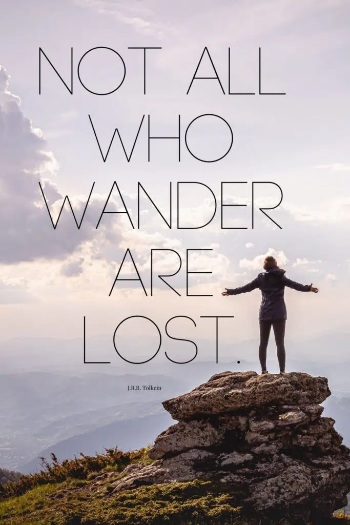 Photo of a woman standing on a larger rock posing triumphantly. Text overlay reads "Not all who wander are lost."