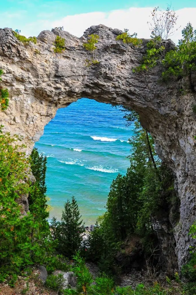 Photo of a rock arch with a lake in the background on Mackinac Island in Michigan.
