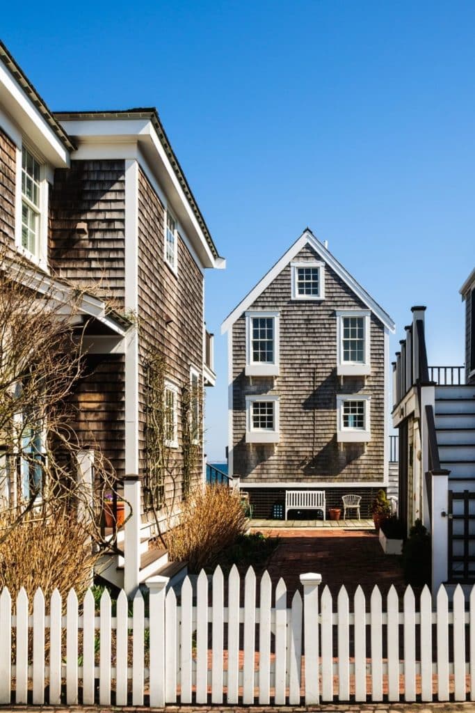 Photo of 2 wood-shingled beach houses in Provincetown, Massachusetts from the road.