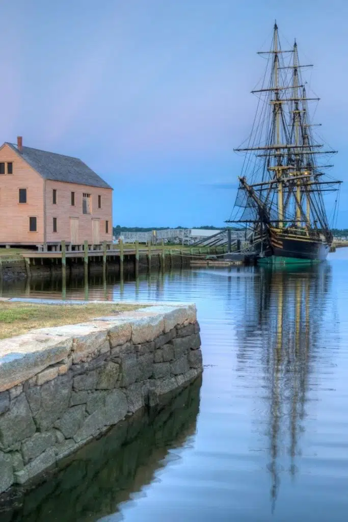 Photo of a historic house and sailing ship along the Salem, Massachusetts harbor.