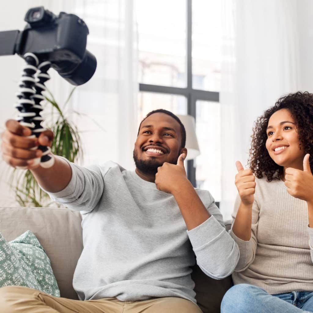 Photo of 2 young adults with a camera for blogging.