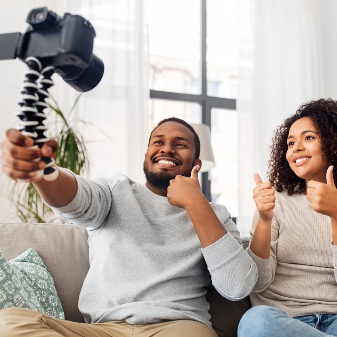 Photo of 2 young adults with a camera for blogging.