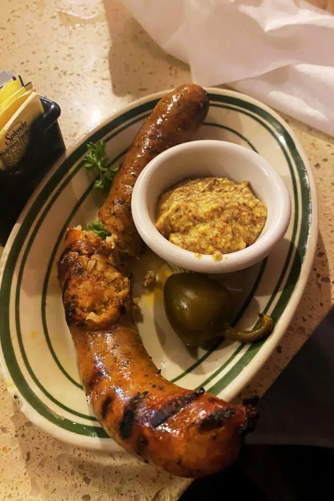 Flat lay of a plate of boudin sausage and mustard.