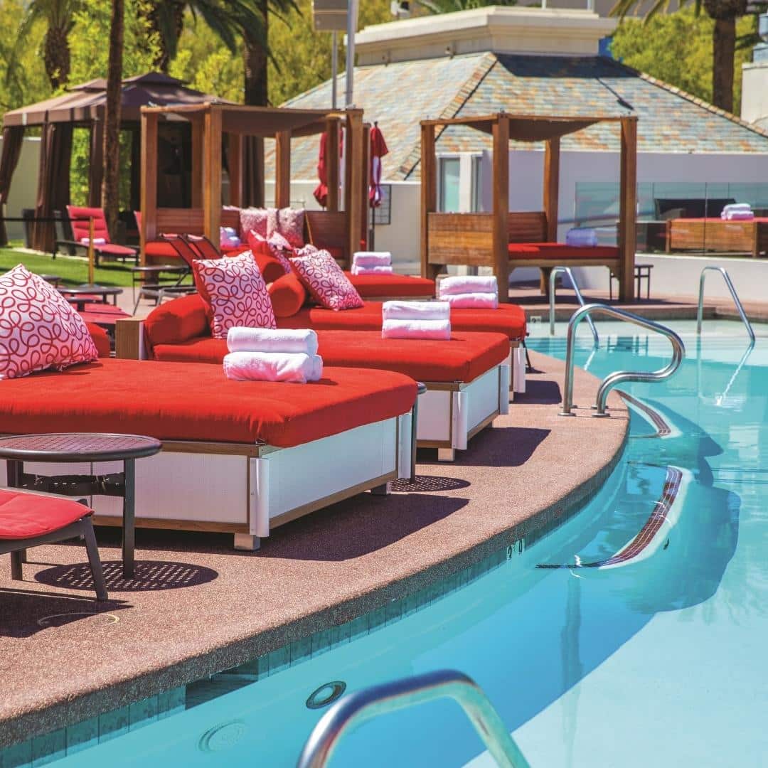 Photo of red day beds surrounding a pool at Moorea Beach Club at Mandalay Bay in Las Vegas.