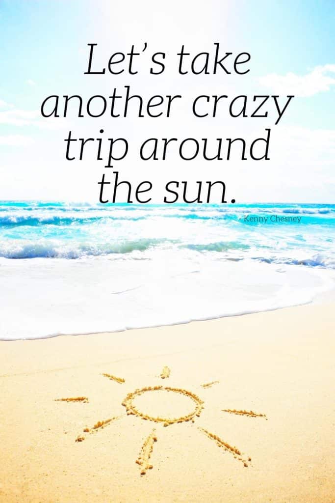 Photo of an empty beach with a sun drawn in the sand. Text above the photo reads "Let's take another crazy trip around the sun. - Kenny Chesney"