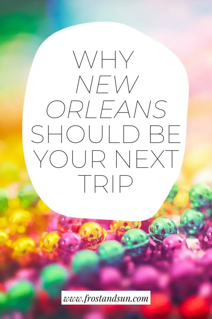 Closeup of a pile of Mardi Gras beads. Text overlay reads "Why New Orleans Should Be Your Next Trip."