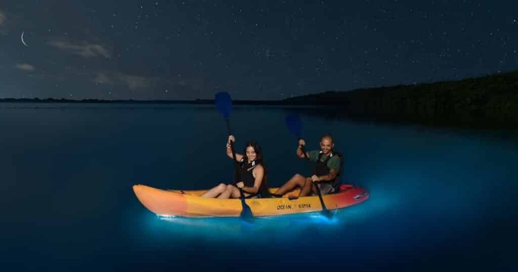 Photo of 2 people kayaking in Fajardo Bioluminescent Bay at night.