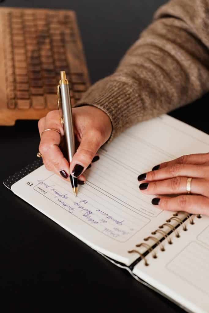 Closeup of someone journaling in a notebook.