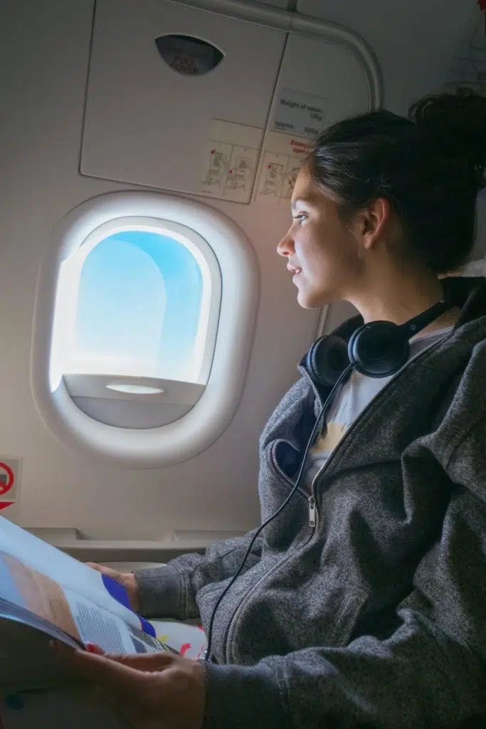 Photo of a woman reading on a plane.