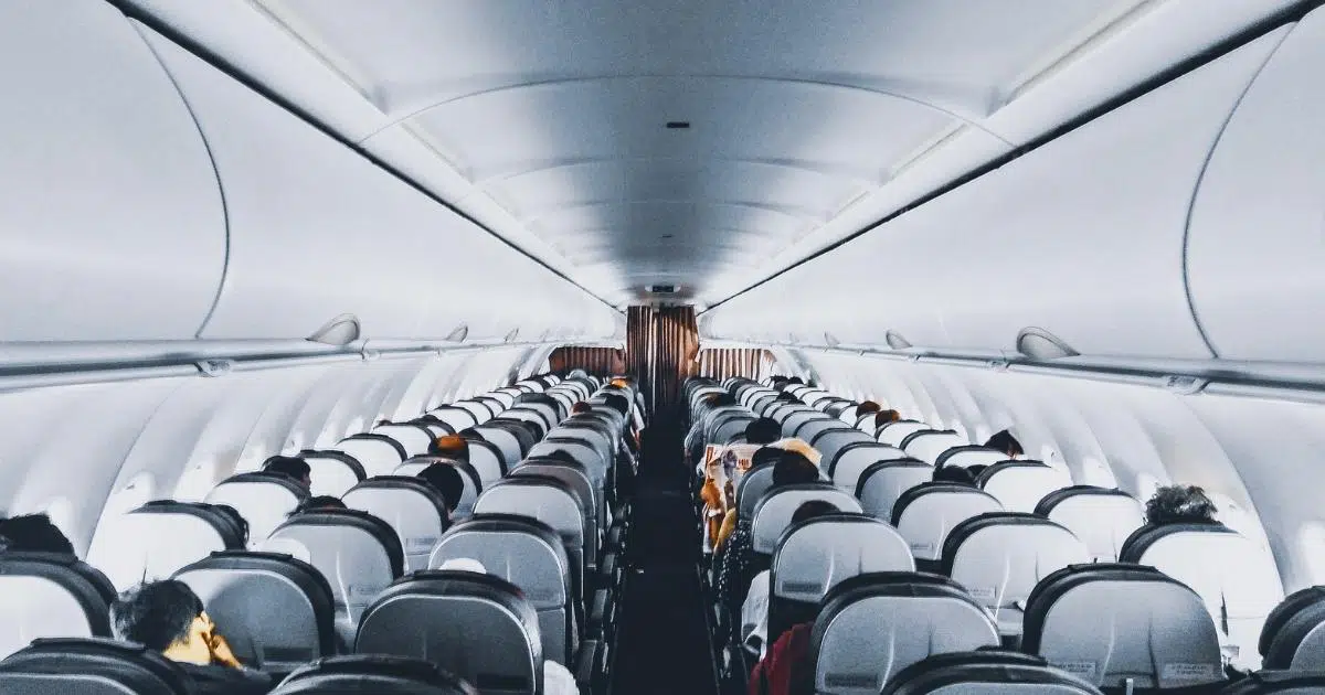 Photo from inside a plane with passengers seated.