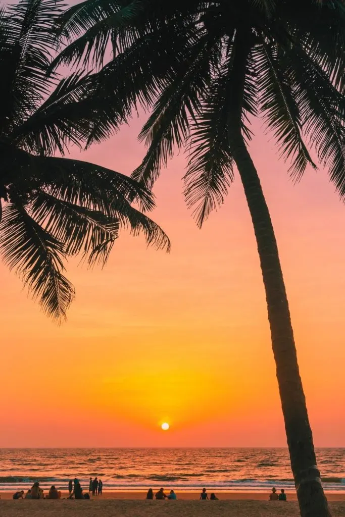Photo of people watching the sunset from Waikiki Beach in Hawaii.