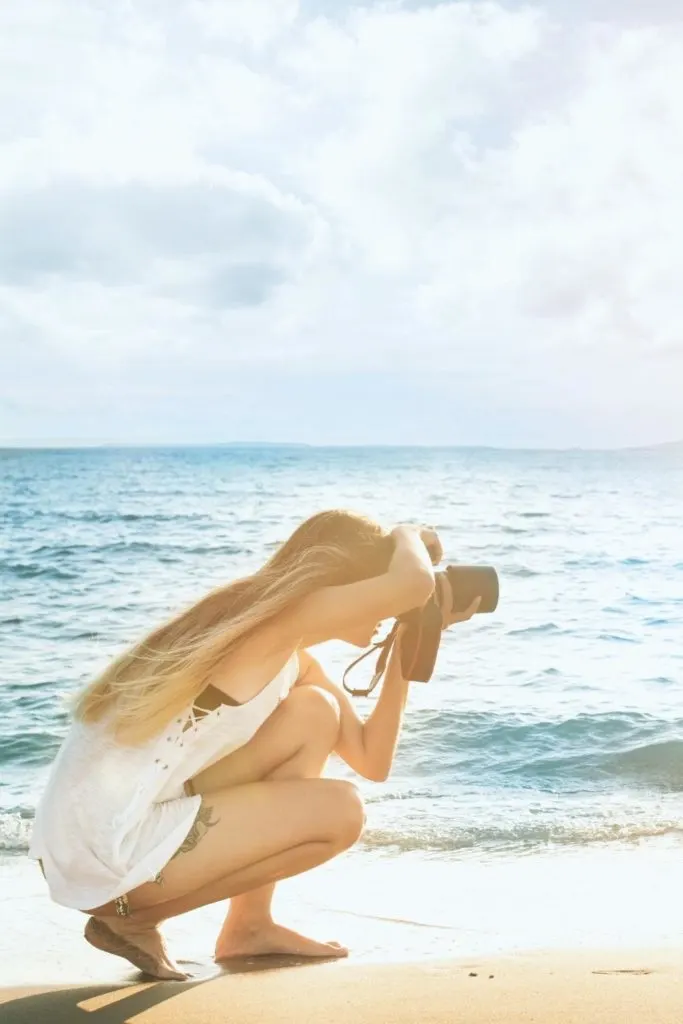 Photo of a woman taking photos on the beach.