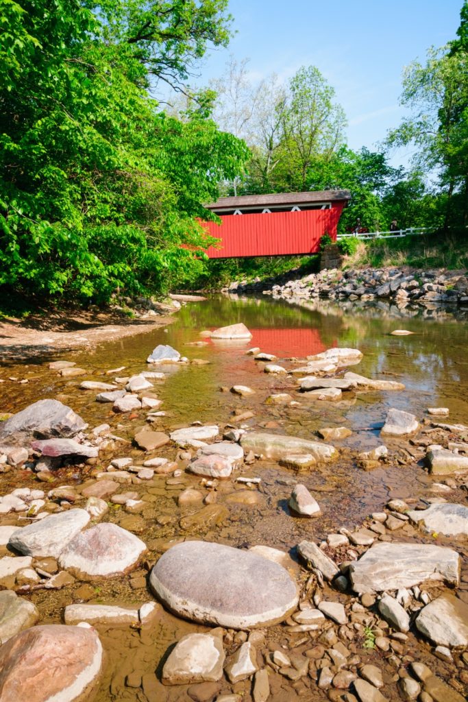 Photo of a red covered bridge over a river.
