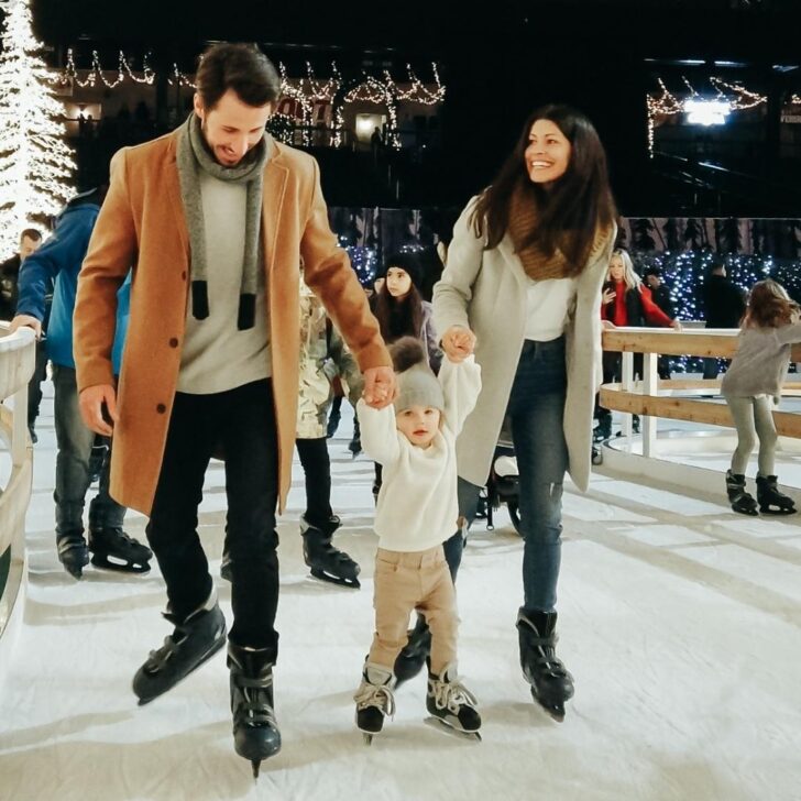 Photo of 2 adults and a child ice skating at Enchant Christmas in Las Vegas.