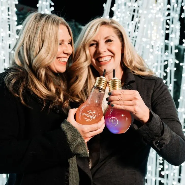 Photo of 2 women drinking cocktails at Enchant Christmas.