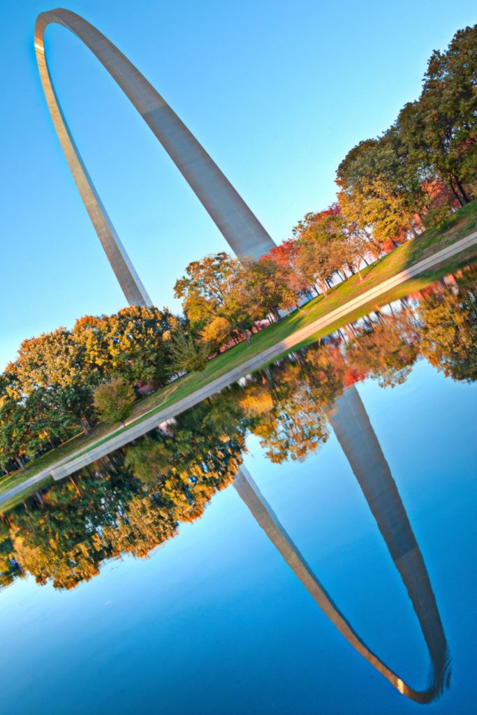 Photo of the Gateway Arch in St. Louis, Missouri, reflecting in the river nearby.