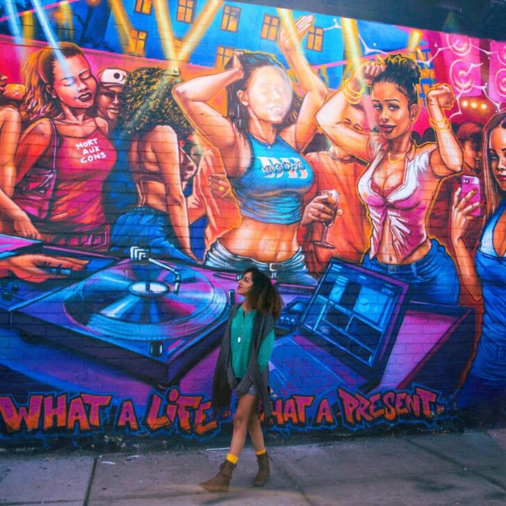 Photo of a woman walking by the "Joie de Vivre" street art mural by PWOZ in Las Vegas' Arts District.