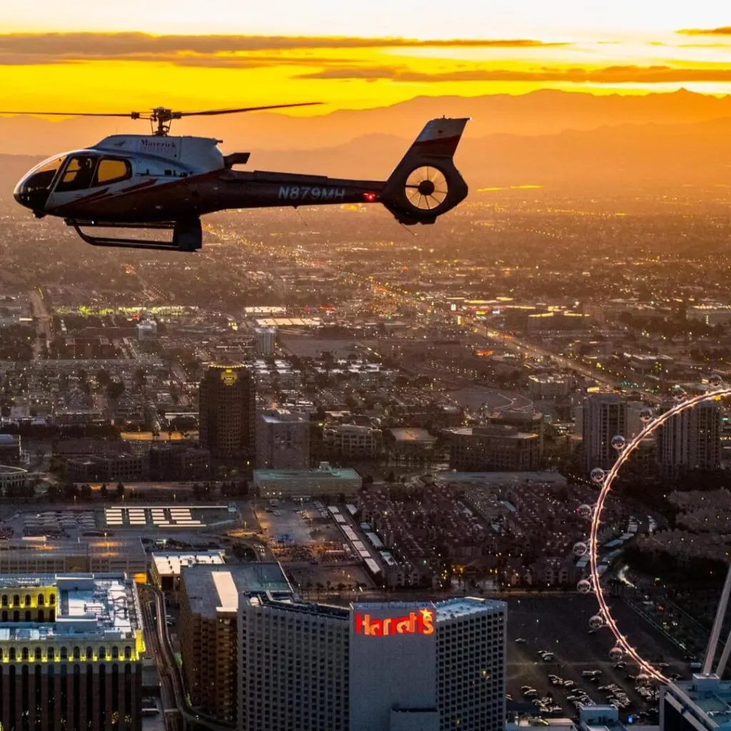 Photo of a helicopter tour flying over the Vegas strip at sunset.