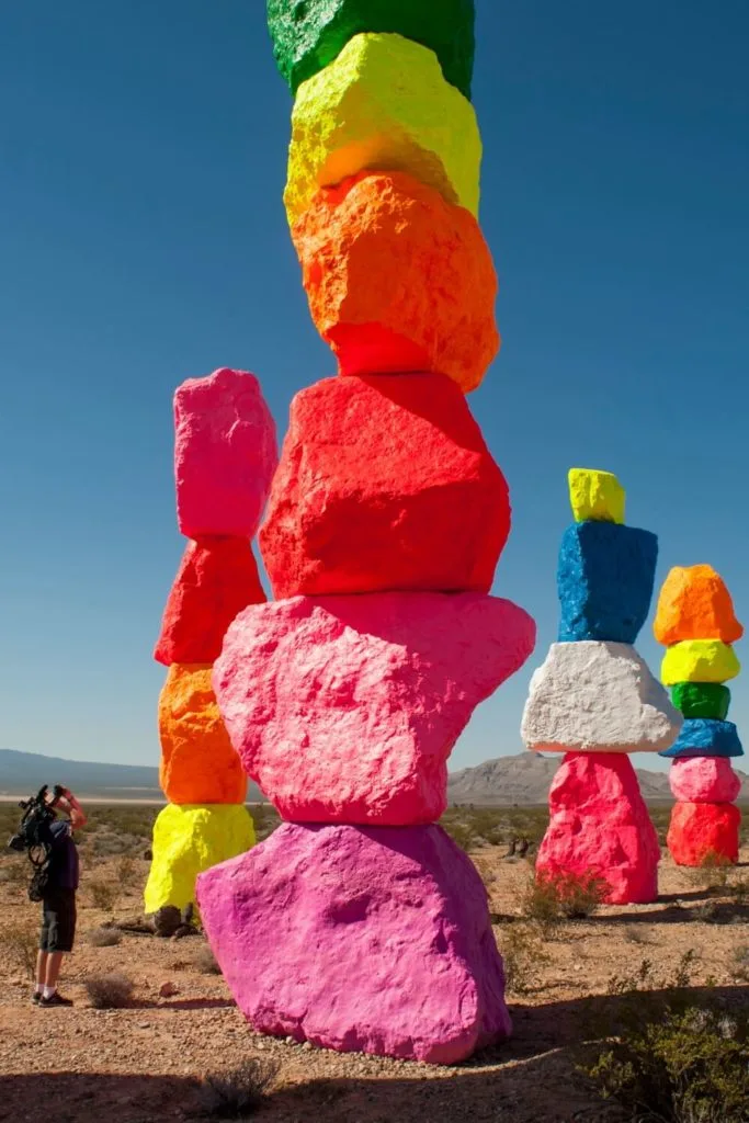 Photo of a person filming the Seven Magic Mountains public art installation.