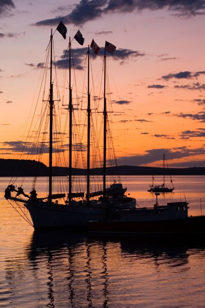 Photo of a silhouetted sailboat in Frenchman Bay during sunset.