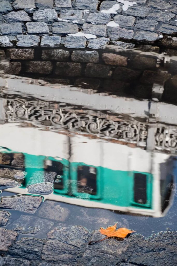 Photo of the reflection of a Paris Metro train in a puddle.