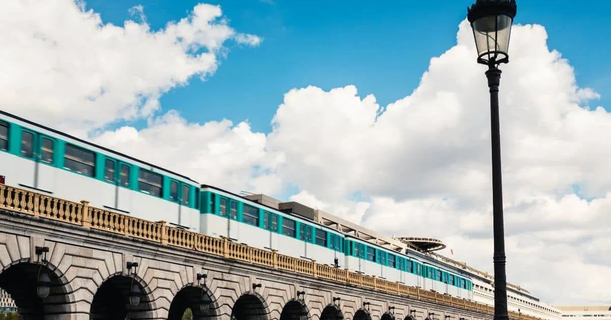 Photo of a Paris Metro train speeding by on a bridge.