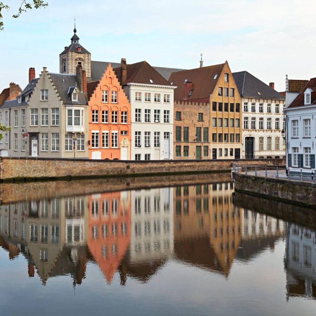 Photo of houses reflecting in a canal in Bruges, Belgium.