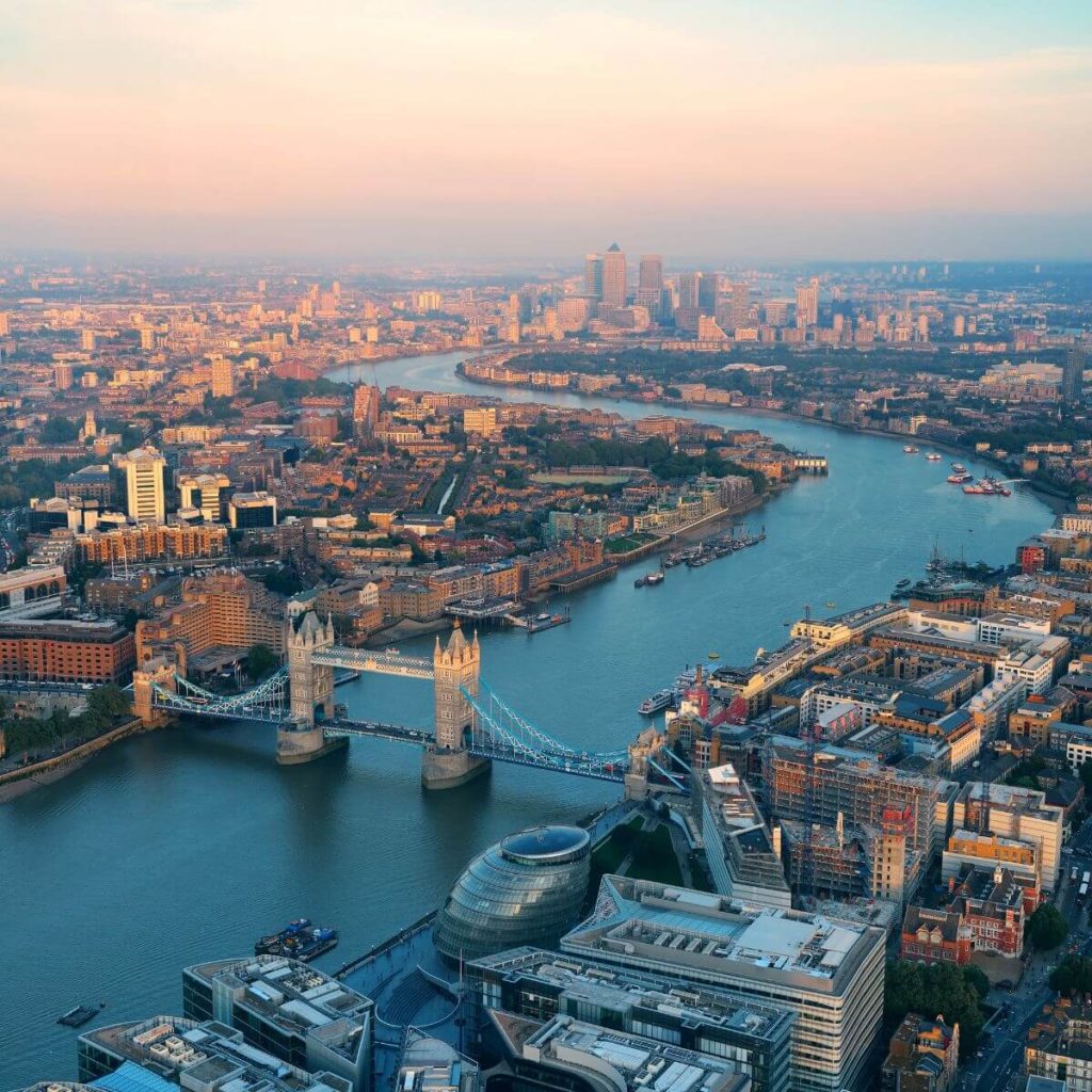 Photo of London from the air, showing the Thames River in the middle and the Tower Bridge with the city on each side.