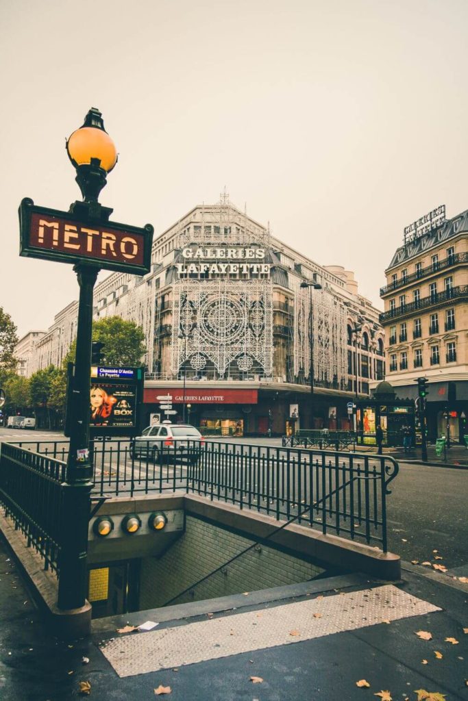 Photo of a metro station entrance across the street from Galeries Lafayette in Paris, France.
