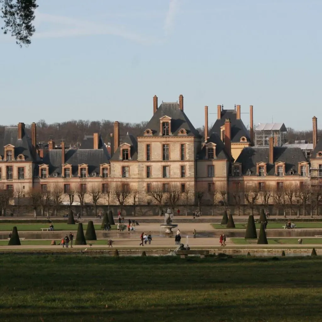 Photo of Château de Fontainebleau during winter with bare trees.