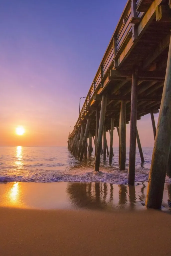 Photo from below a boardwalk at Virginia Beach in Virginia during sunrise.