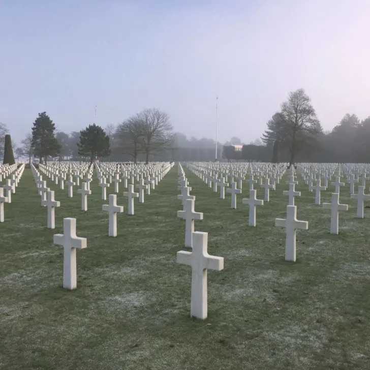 Photo of the American Cemetery in Normandy, France on a foggy day, with seemingly endless rows of white marble crosses.