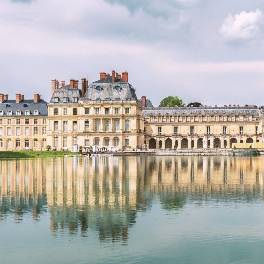 Photo of Chateau de Fontainebleau, reflecting in water.