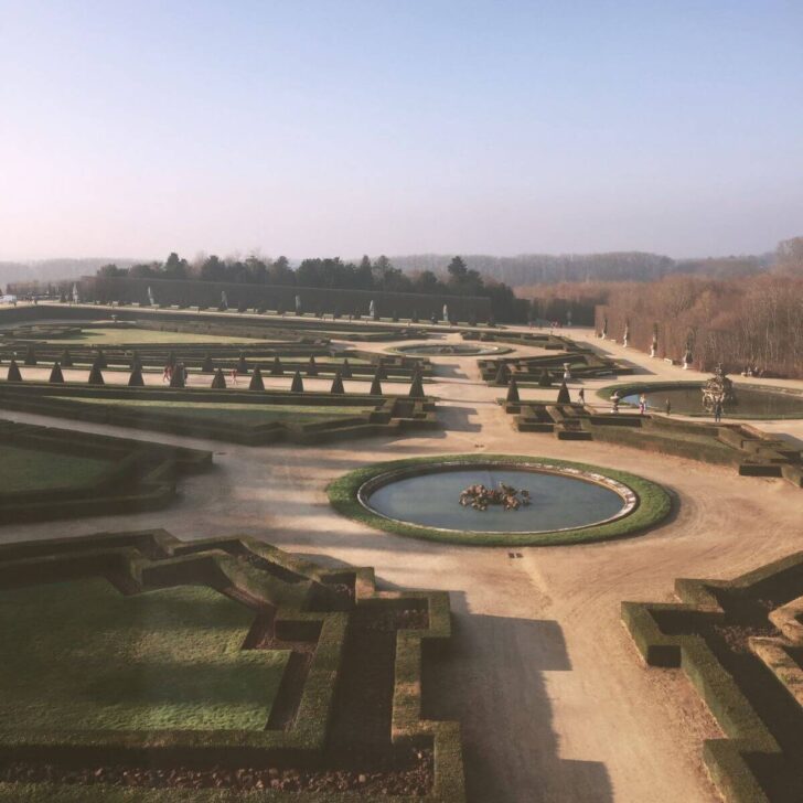 Photo of the well-manicured gardens behind the Chateau de Versailles.