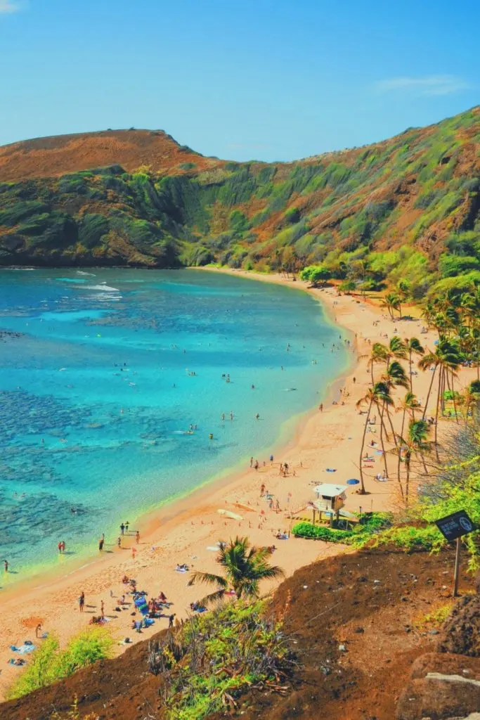 Photo of Hanauma Bay Preserve from above with people in the water and the beach.