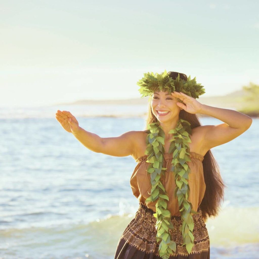 Photo of a woman performing a hula dance on the beach in Hawaii.