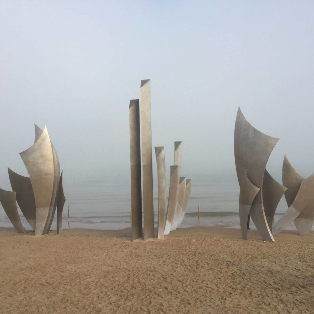 Photo of the Les Braves monument on Omaha Beach on a foggy Winter day.