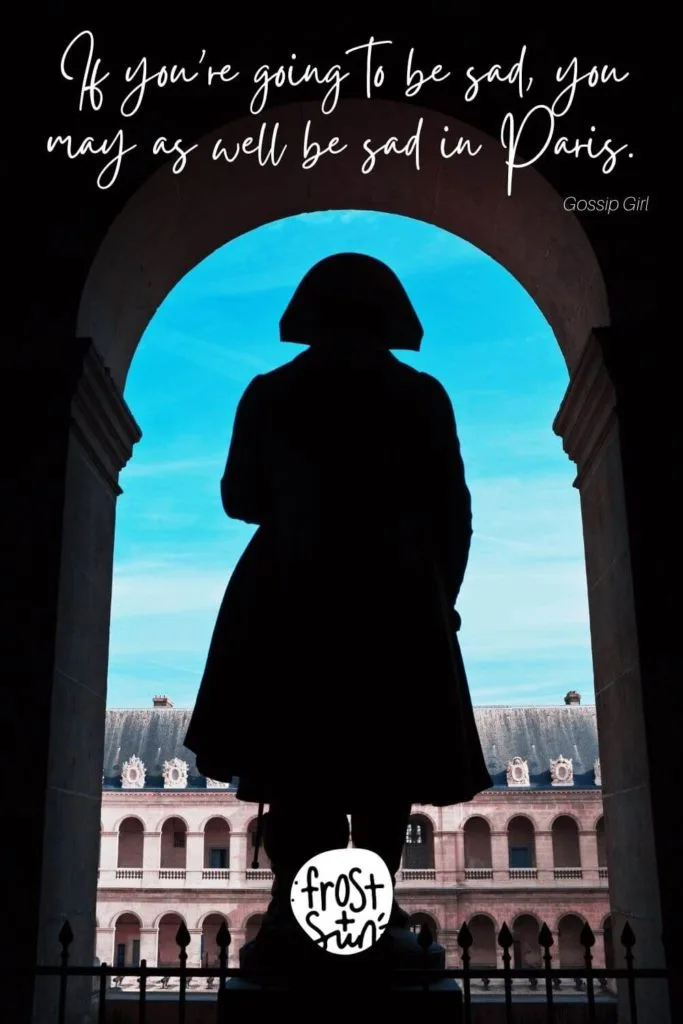 Photo of a woman standing in an arch with the city of Paris in the background. Text above the photo reads "If you're going to be sad, you may as well be sad in Paris."